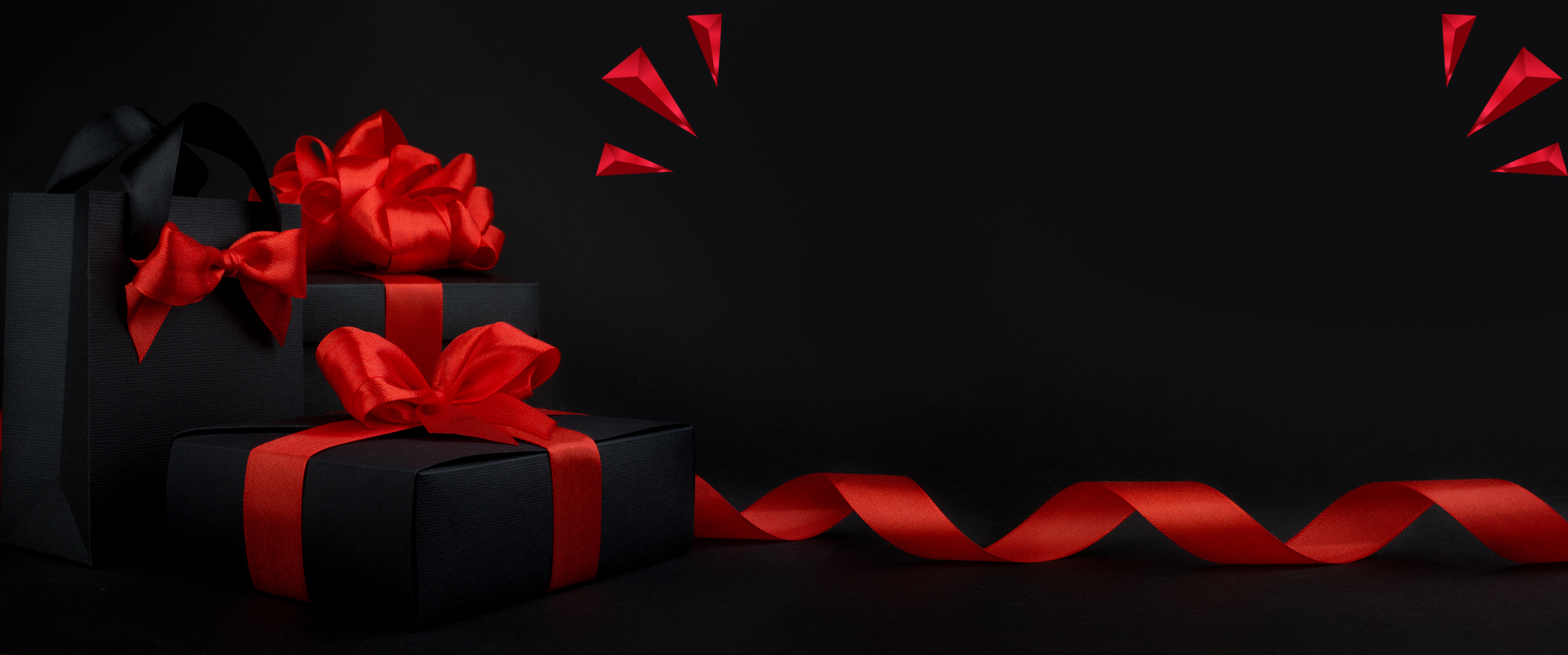 Black gift boxes with red ribbons on a black background
